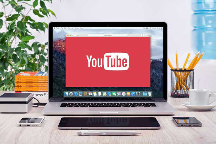 YouTube logo on a laptop screen on desk