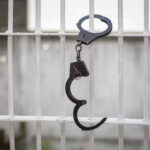 Handcuffs hanging on a barred window