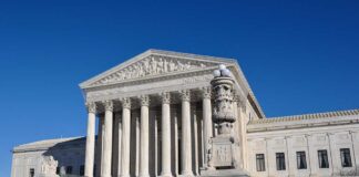 The Supreme Court building with large columns and a clear blue sky
