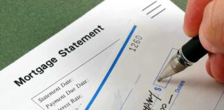 A person writing a check on a mortgage statement