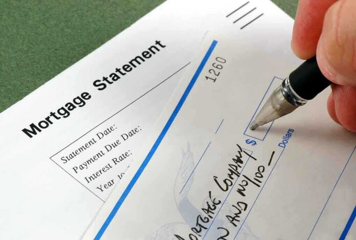 shutterstock_3405204.jpg A person writing a check on a mortgage statement