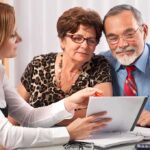 A financial advisor discussing documents with an elderly couple