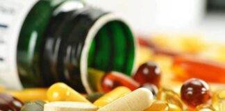 Assorted vitamins and supplements scattered around an overturned bottle