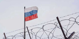 Flag above barbed wire fence