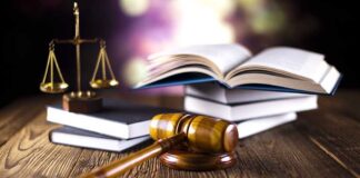 A gavel legal books and scales of justice on a wooden table