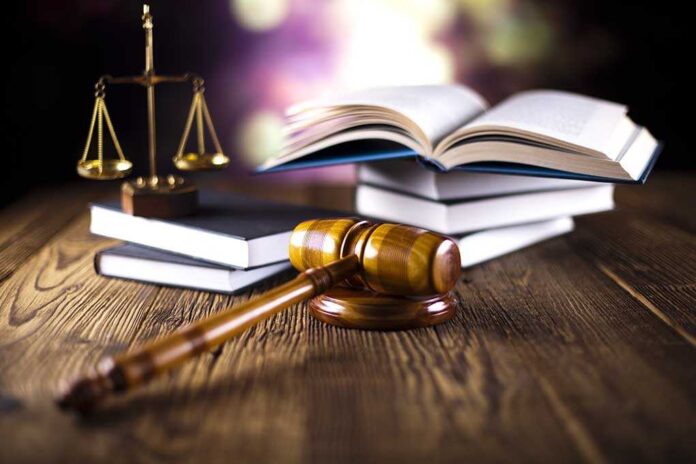 A gavel legal books and scales of justice on a wooden table