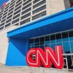 Exterior view of the CNN headquarters with a large red logo and blue entrance