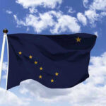 Biden Drilling Ban Obliterated—23 Million Acres Unleashed Alaska state flag flying against a blue sky.