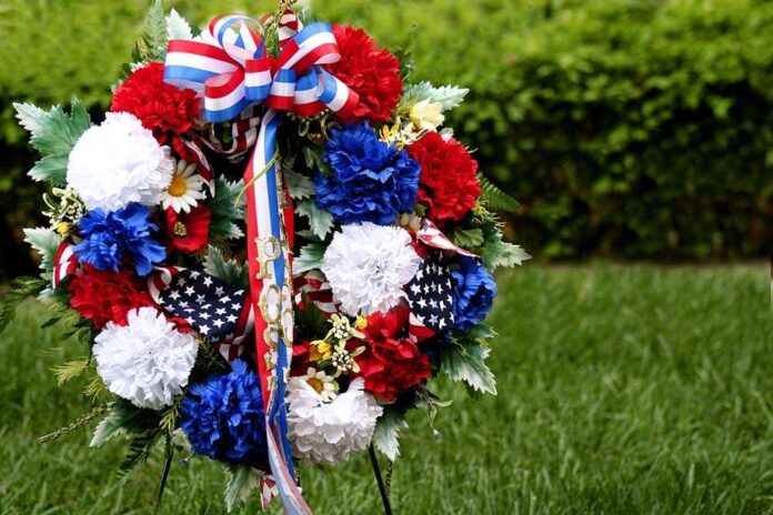 A patriotic memorial wreath adorned with red white and blue flowers