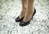 Congresswoman’s $5M Heist for Luxury Life A pair of black high heels standing on a floor covered with dollar bills