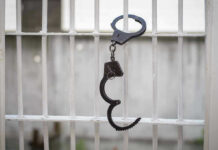 Handcuffs hanging on a barred window.