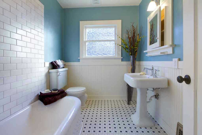 71616208 Modern bathroom with blue walls and white fixtures.
