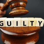 A gavel above wooden blocks spelling GUILTY