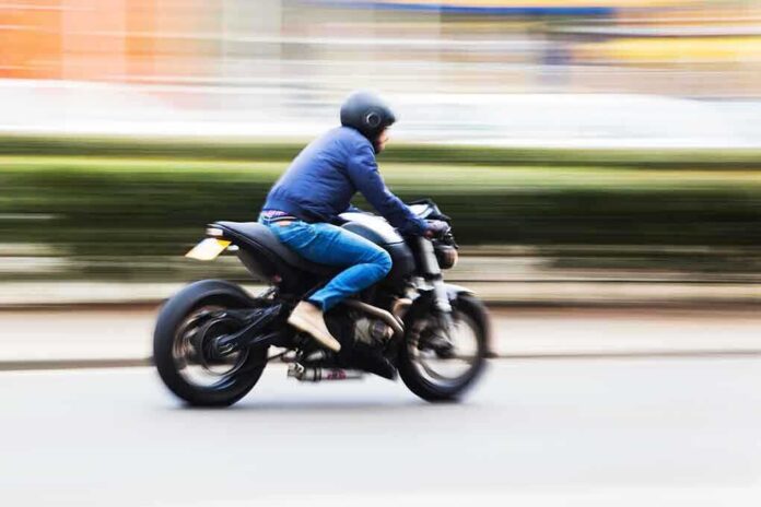 shutterstock_156053021.jpg A person riding a motorcycle swiftly through an urban area