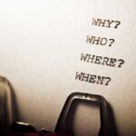 Close-up of a typewritten page with four questions: Why?, Who?, Where?, When?