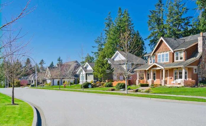 A sunny suburban neighborhood with houses and green lawns