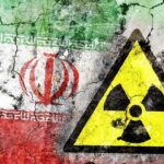 A cracked wall featuring the Iranian flag and a nuclear warning symbol