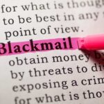 Blackmail Scandal: CIA’s Hidden Playbook Close-up of a dictionary page with the word blackmail highlighted in pink