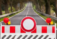 Traffic barrier with a red and white sign blocking a road