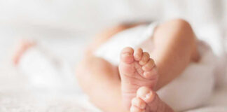 Close-up of baby feet lying on blanket.