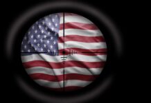 War Drums Rise: Iran Targets U.S. Bases View of the American flag through a sniper scope