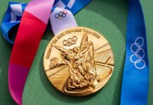Gold Olympic medal from the Tokyo 2020 Games with a colorful ribbon