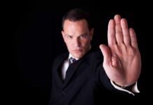550 TRAINING Schools Busted! Businessman in a suit making a stop gesture with his hand
