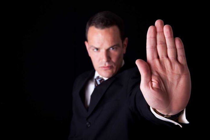shutterstock_52708414.jpg Businessman in a suit making a stop gesture with his hand