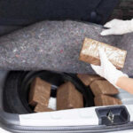 Person removing packages from car trunk.