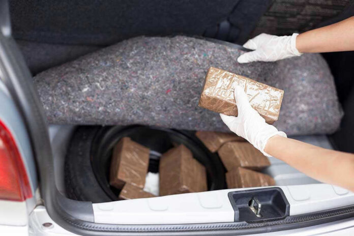 Person removing packages from car trunk.