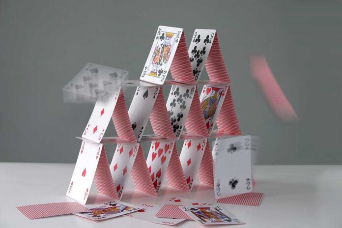 A house of cards collapsing with some cards in motion