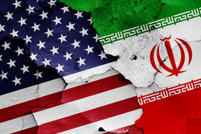 Cracked American and Iranian flags painted on a wall.