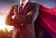Businessman wearing a cape, standing confidently.