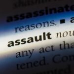 Close-up of a dictionary page showing the definition of the word 'assault'