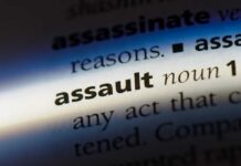 Close-up of a dictionary page showing the definition of the word 'assault'