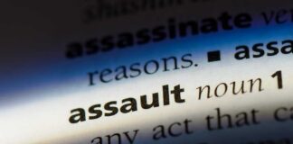 Close-up of a dictionary page showing the definition of the word 'assault'