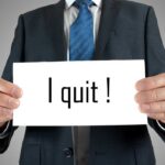 Resignation Flood Threatens House Control A man in a suit holding a sign that says I quit