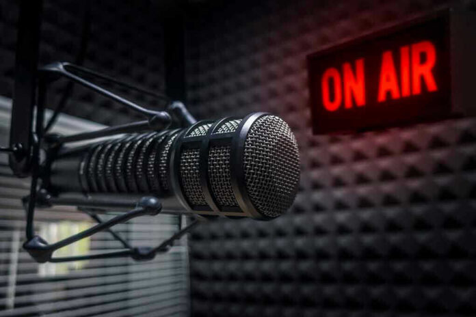 1218528058 Radio microphone in studio with On Air sign.