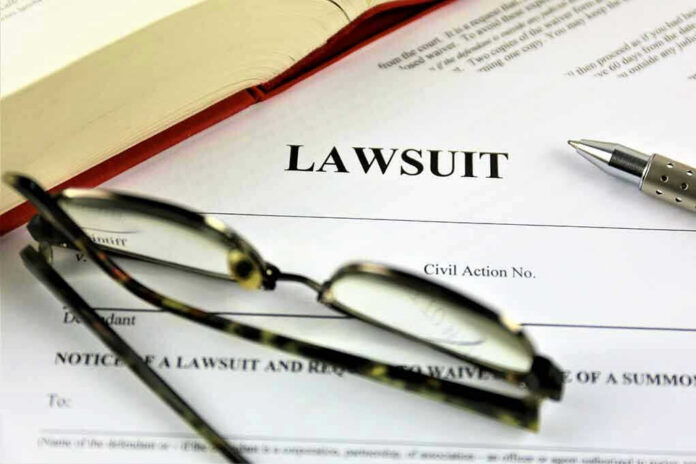 775833220 Lawsuit paperwork with glasses, pen, and an open book.