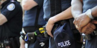 Group of police officers in uniform standing together with a police cap visible