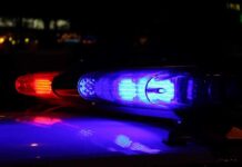 HORRIFYING Crime — VULNERABLE Woman Raped in STATE CARE Facility Close-up of police lights flashing in blue and red at night