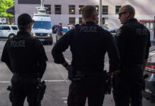The Philadelphia House That Keeps Getting Stranger Three police officers standing on a city street.