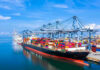 Container ship docked at a busy industrial port.