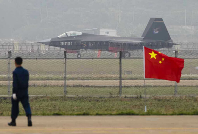 Jet with 31001 marking behind barbed wire fence.
