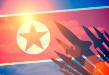 North Korea Hardwires Nuclear Launch Authority North Korean flag with missile silhouettes.