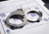 Handcuffs on fingerprint form with fingerprints visible.