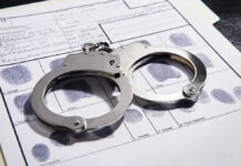 Handcuffs on fingerprint form with fingerprints visible.