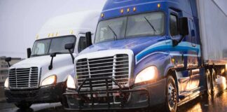 Two semi trucks driving side by side on a wet highway