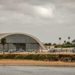airport hangar with helicopters near a shoreline
