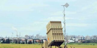 Military defense system deployed in a field with soldiers nearby